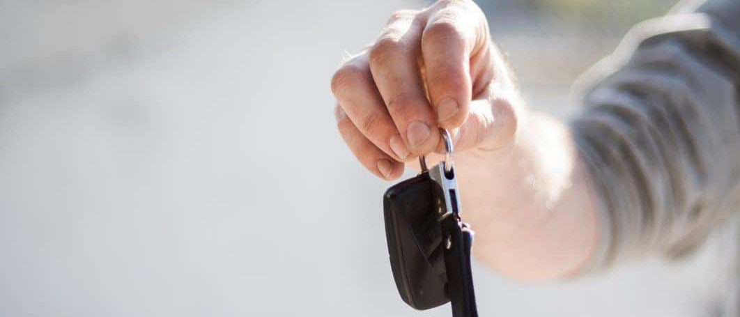 Hand holding out a set of car keys