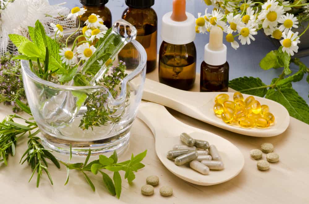 Herbal remedies, essential oil bottles and supplement capsules on a table