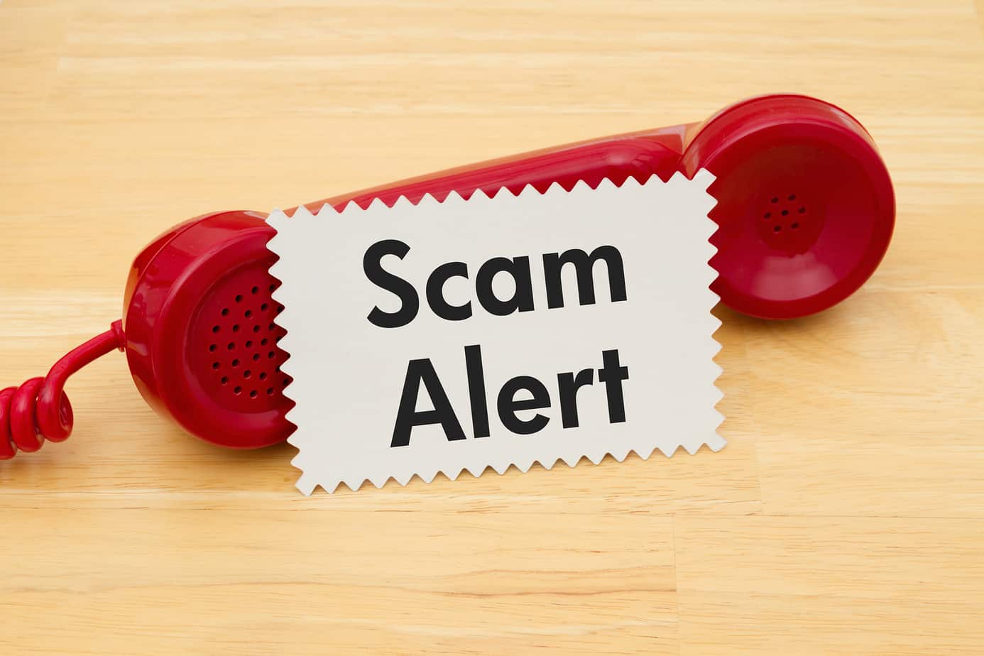 Red telephone handset with a Scam Alert sign