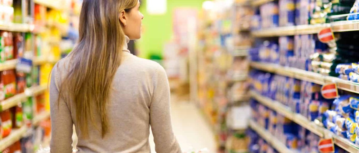 Shopper walking down a grocery store aisle