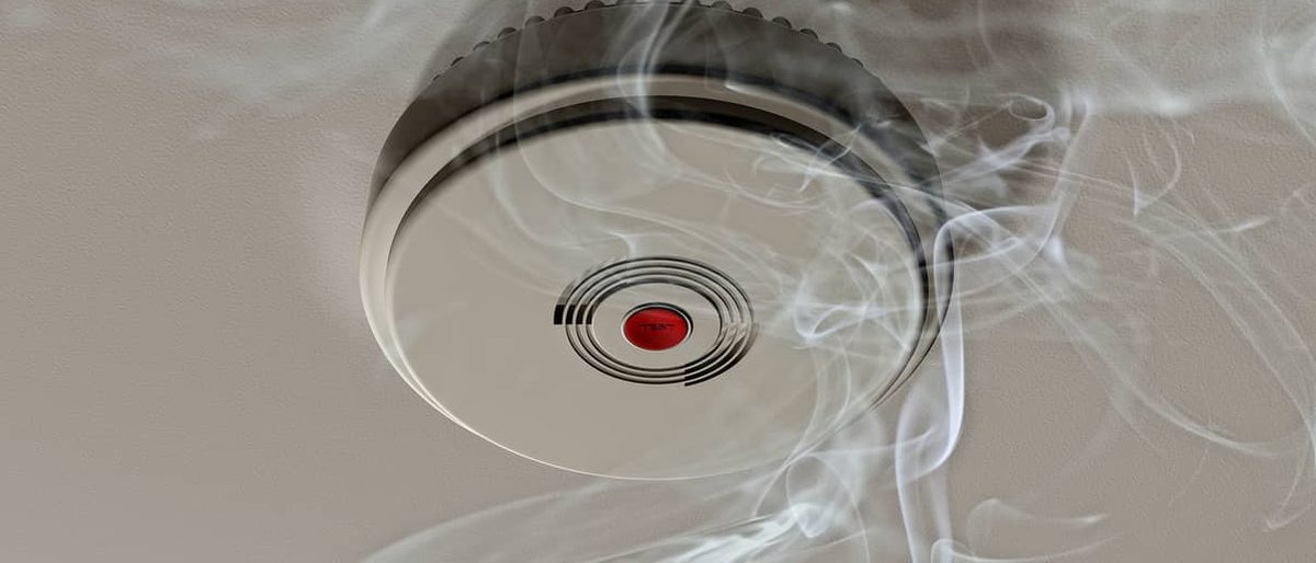 Ceiling smoke alarm with smoke drifting past it