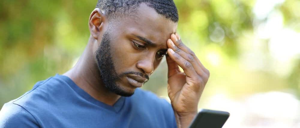 Worried man looking at his smartphone